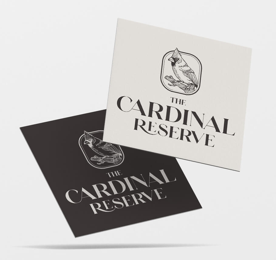 Two business cards, light gray and black, display the logo and name "The Cardinal Reserve" with a stylized cardinal illustration.