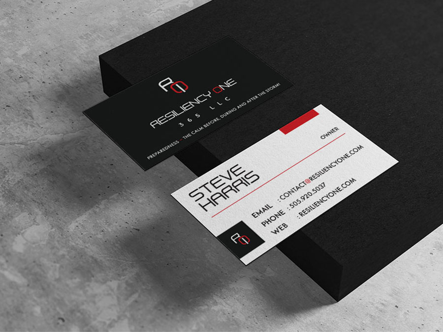 Resiliency One 365 business cards sitting on a black blog over a concrete gray background